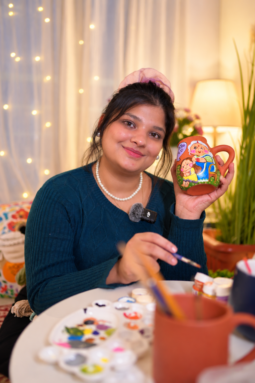 A Happy Earth Studio artisan handpainting a personalised terracotta mug in the Jalna studio